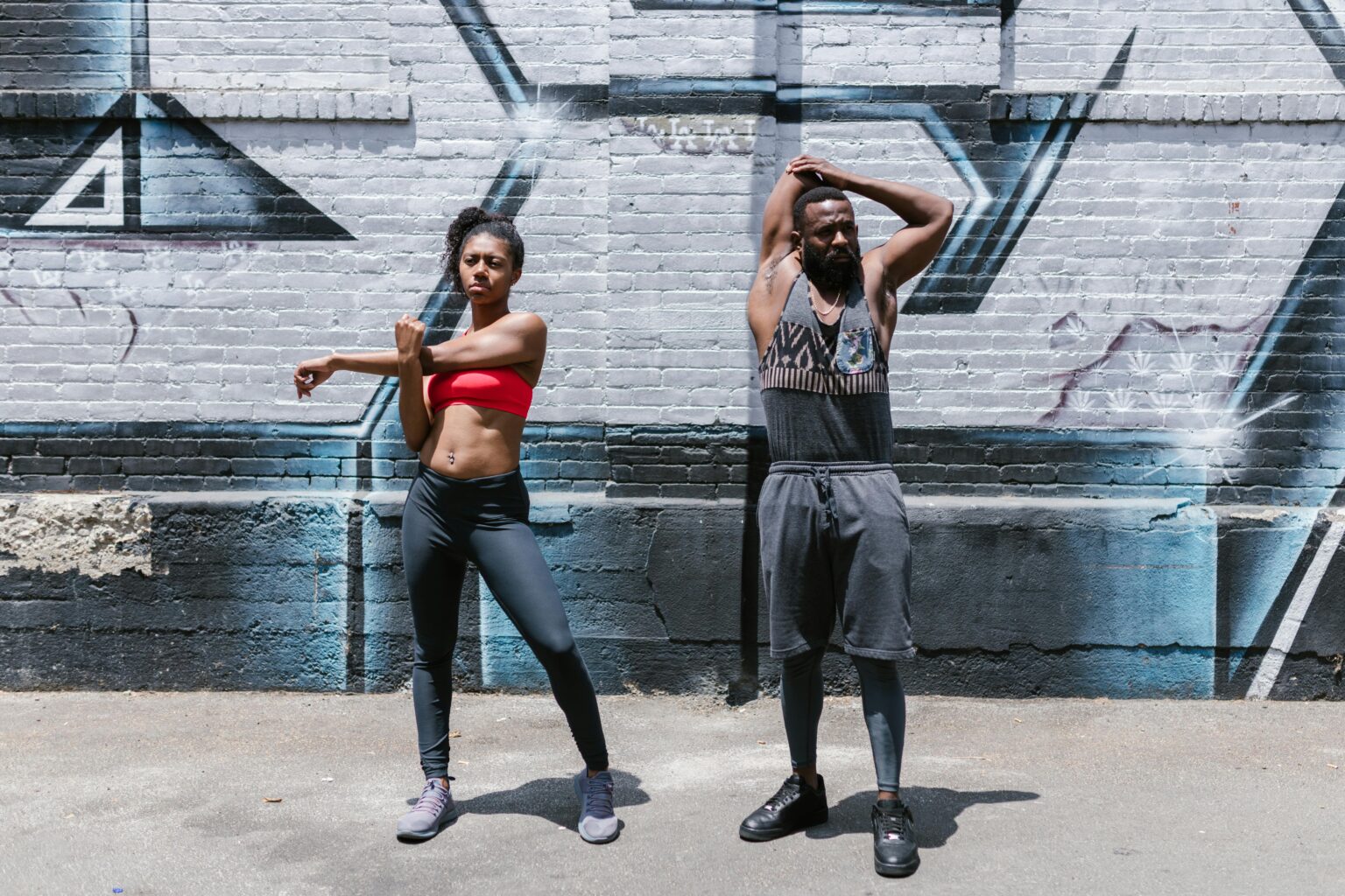 Two people engaging in a dynamic street workout session, showcasing fitness and healthy lifestyle.